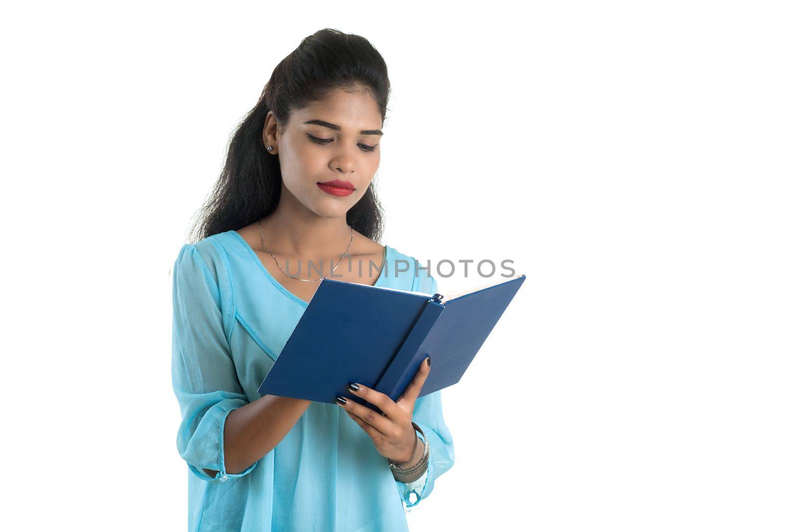 Pretty young girl holding book and posing on white background
