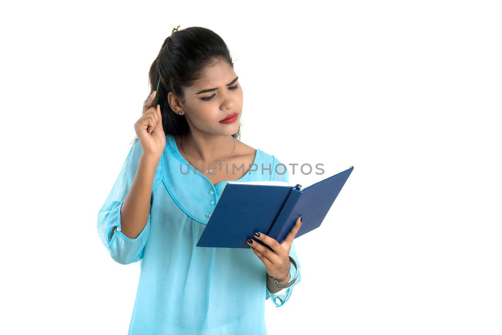 Pretty young girl holding book and posing on white background by DipakShelare