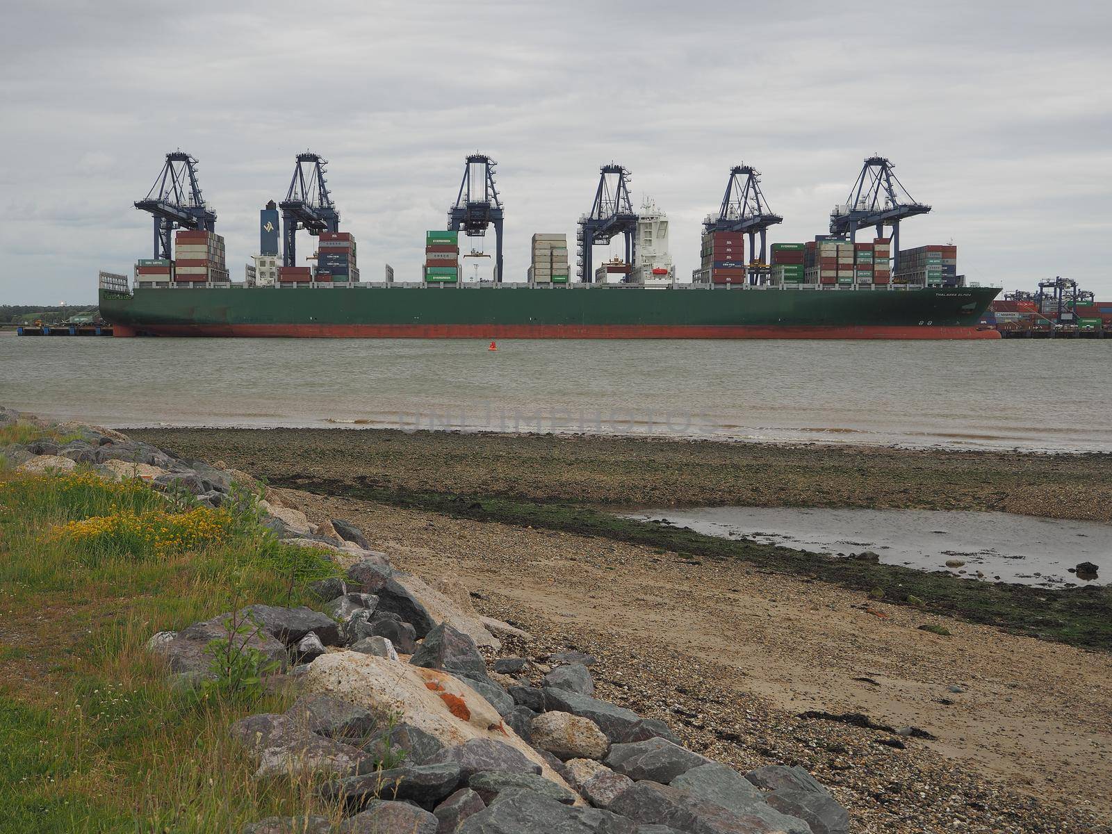 Port of Felixstowe, Suffolk, UK, June 11 2017: Cranes loading containers onto the Thalassa Elpida cargo ship viewed from Shotley Point looking across the River Orwell
