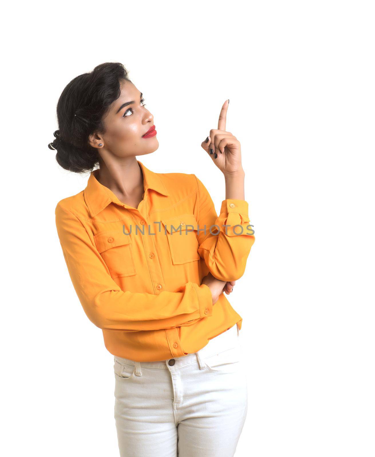 Young smiling girl pointing fingers to copy space on a white background