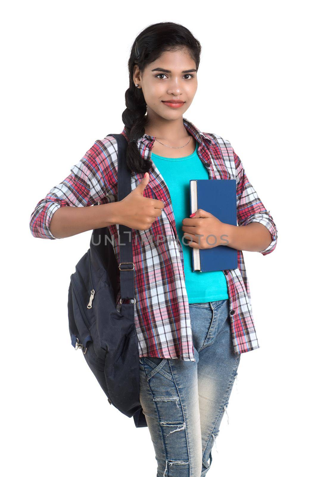 young Indian woman with backpack standing and holding notebooks, posing on a white background.