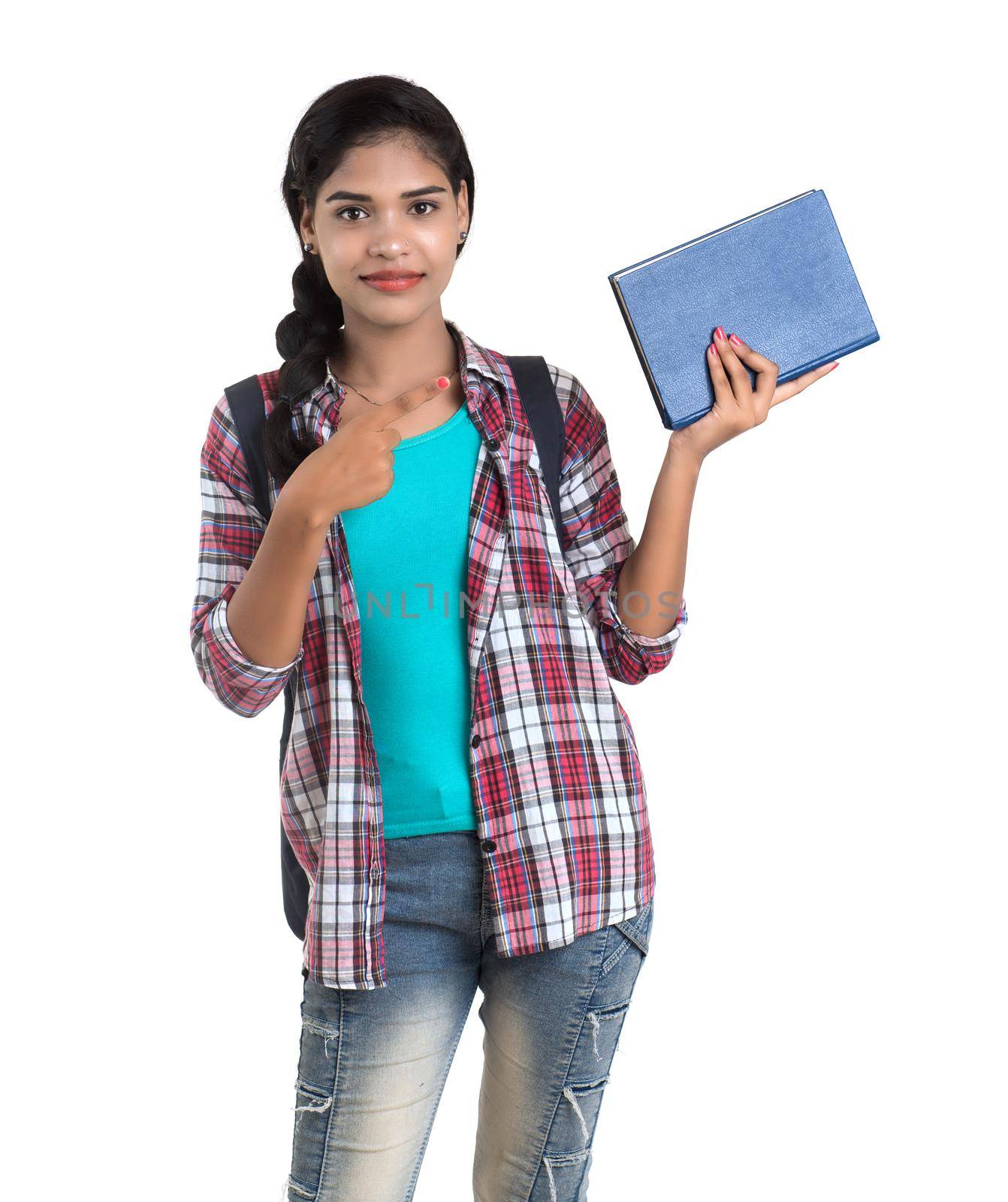 young Indian woman with backpack standing and holding notebooks, posing on a white background. by DipakShelare