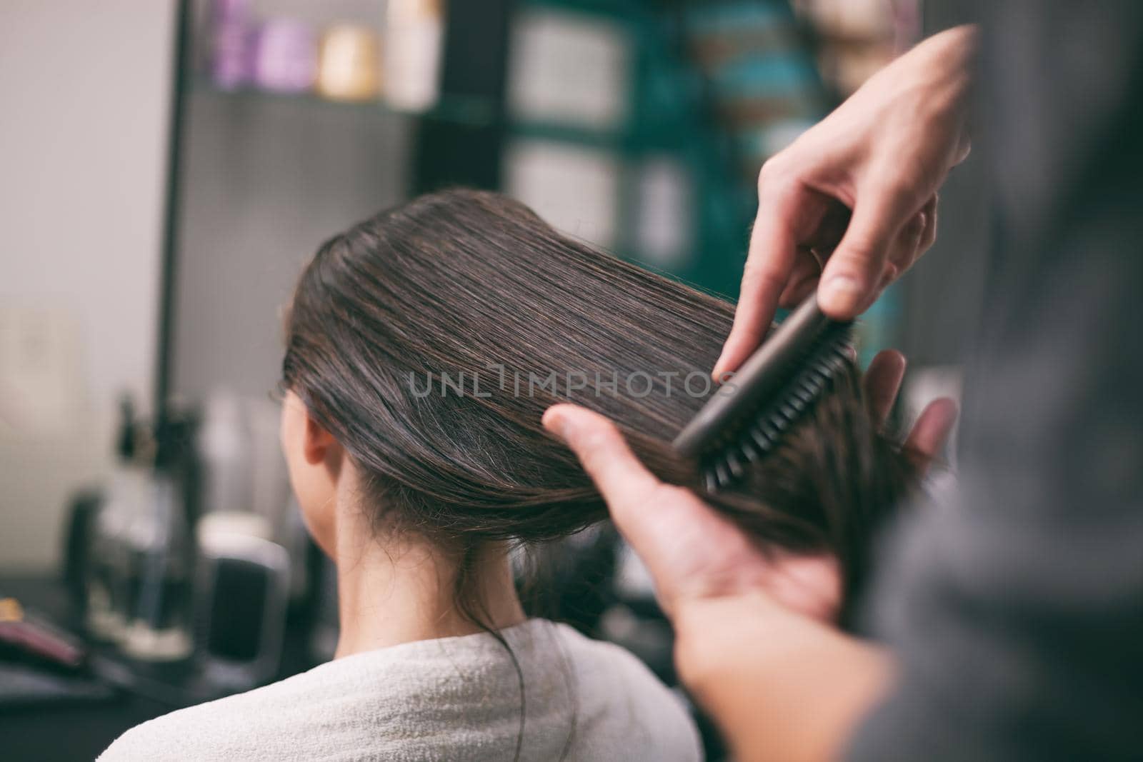 Young woman getting new hairstyle at professional hair styling saloon.