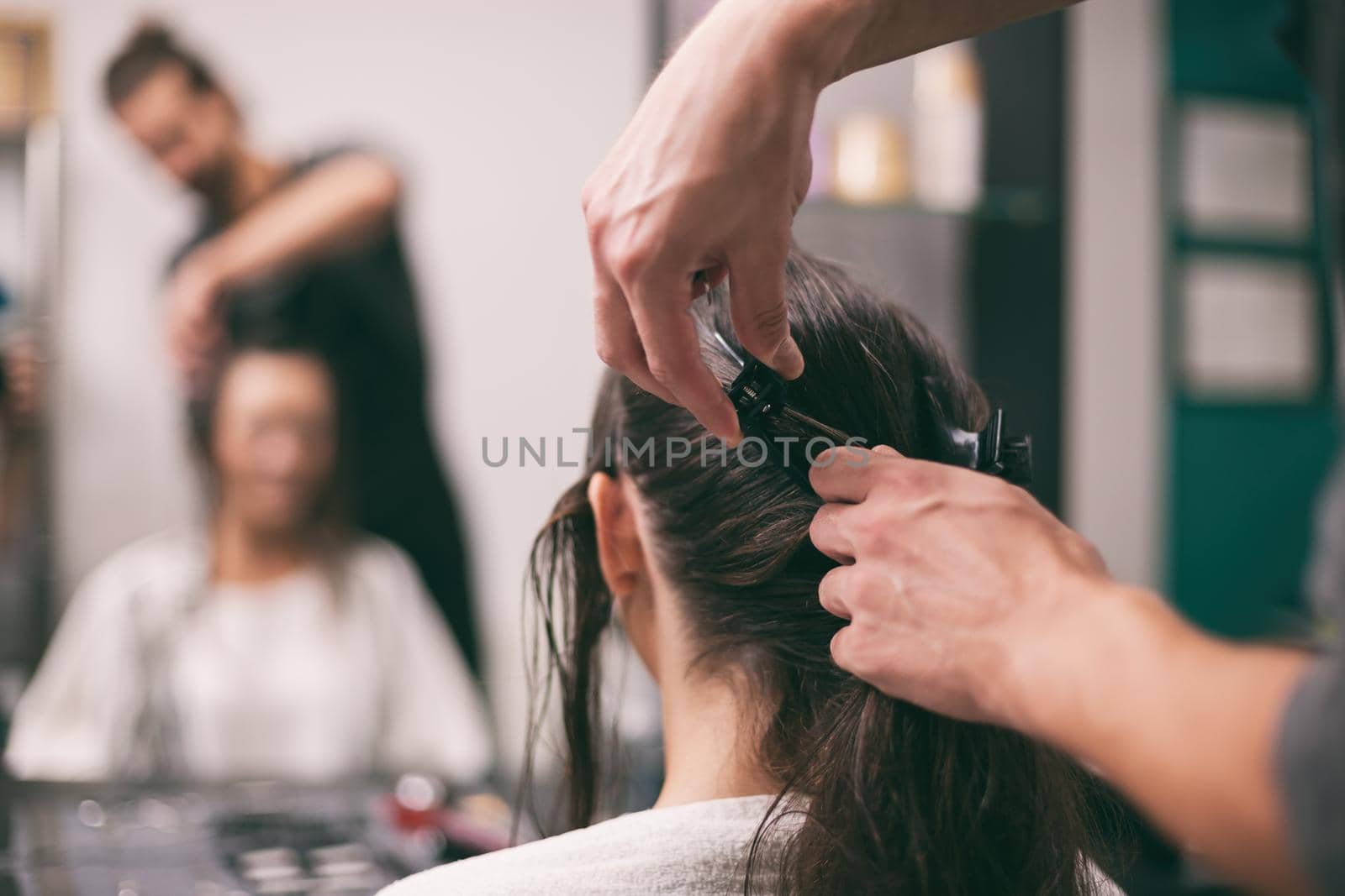 Young woman getting new hairstyle at professional hair styling saloon.