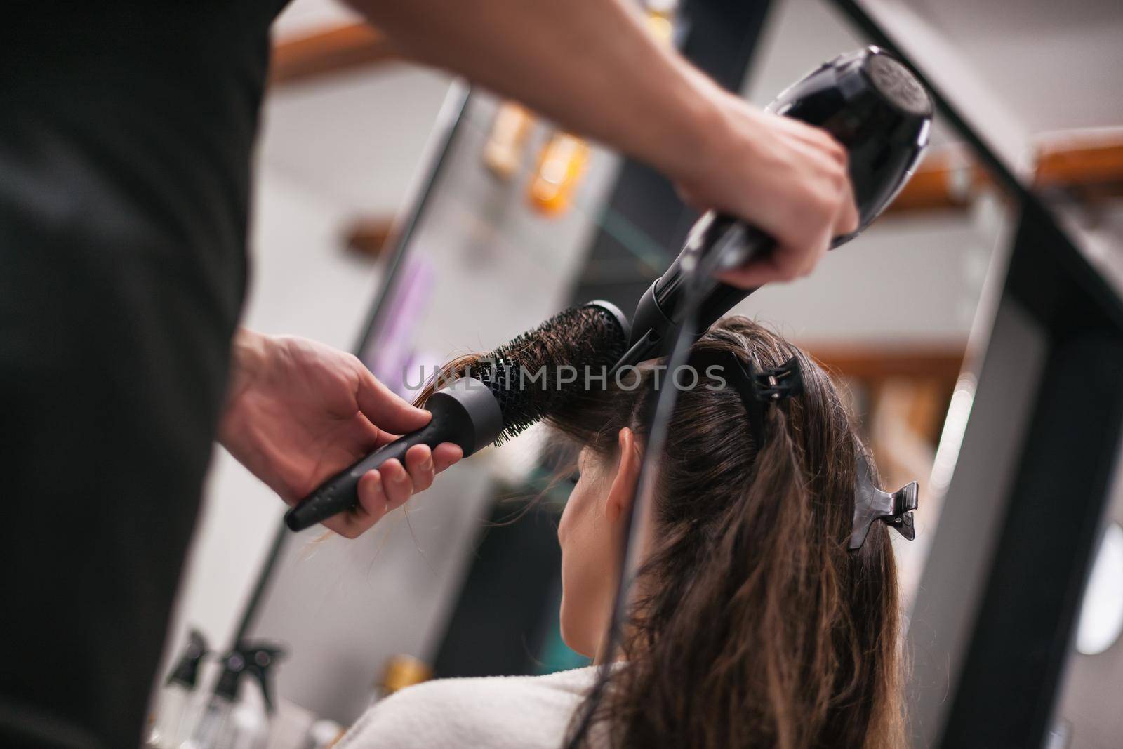 Young woman getting new hairstyle at professional hair styling saloon.