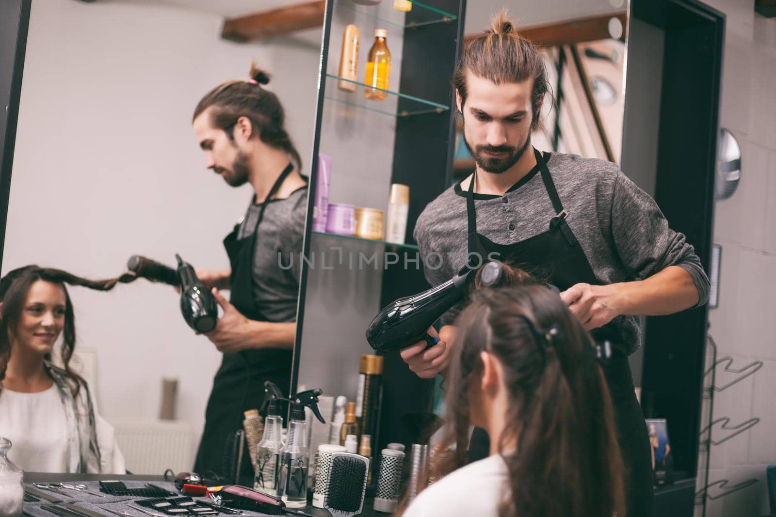 Young woman getting new hairstyle at professional hair styling saloon.