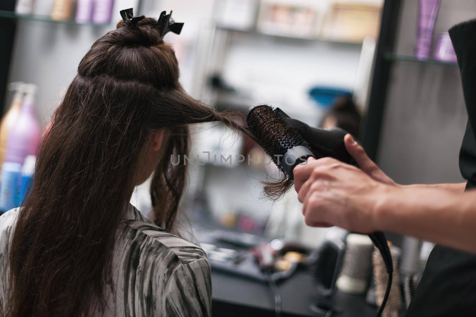 Young woman getting new hairstyle at professional hair styling saloon.