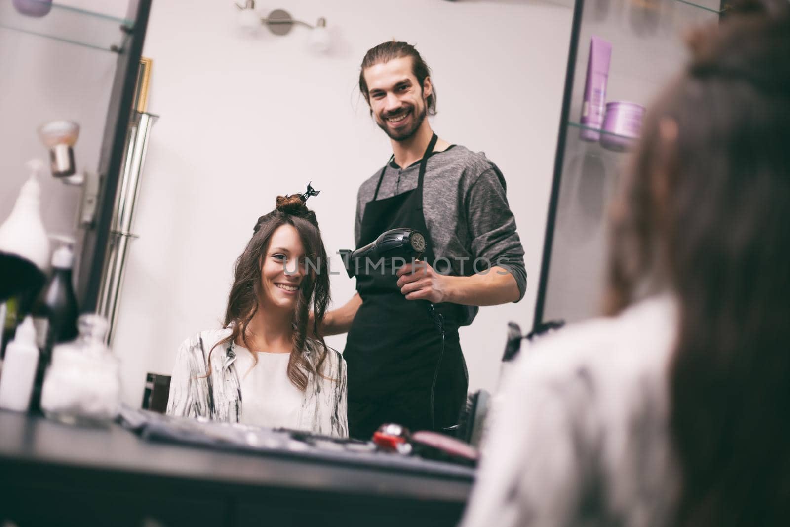 Young woman getting new hairstyle at professional hair styling saloon.