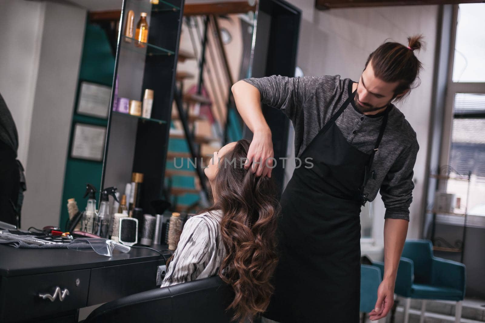 Young woman getting new hairstyle at professional hair styling saloon.
