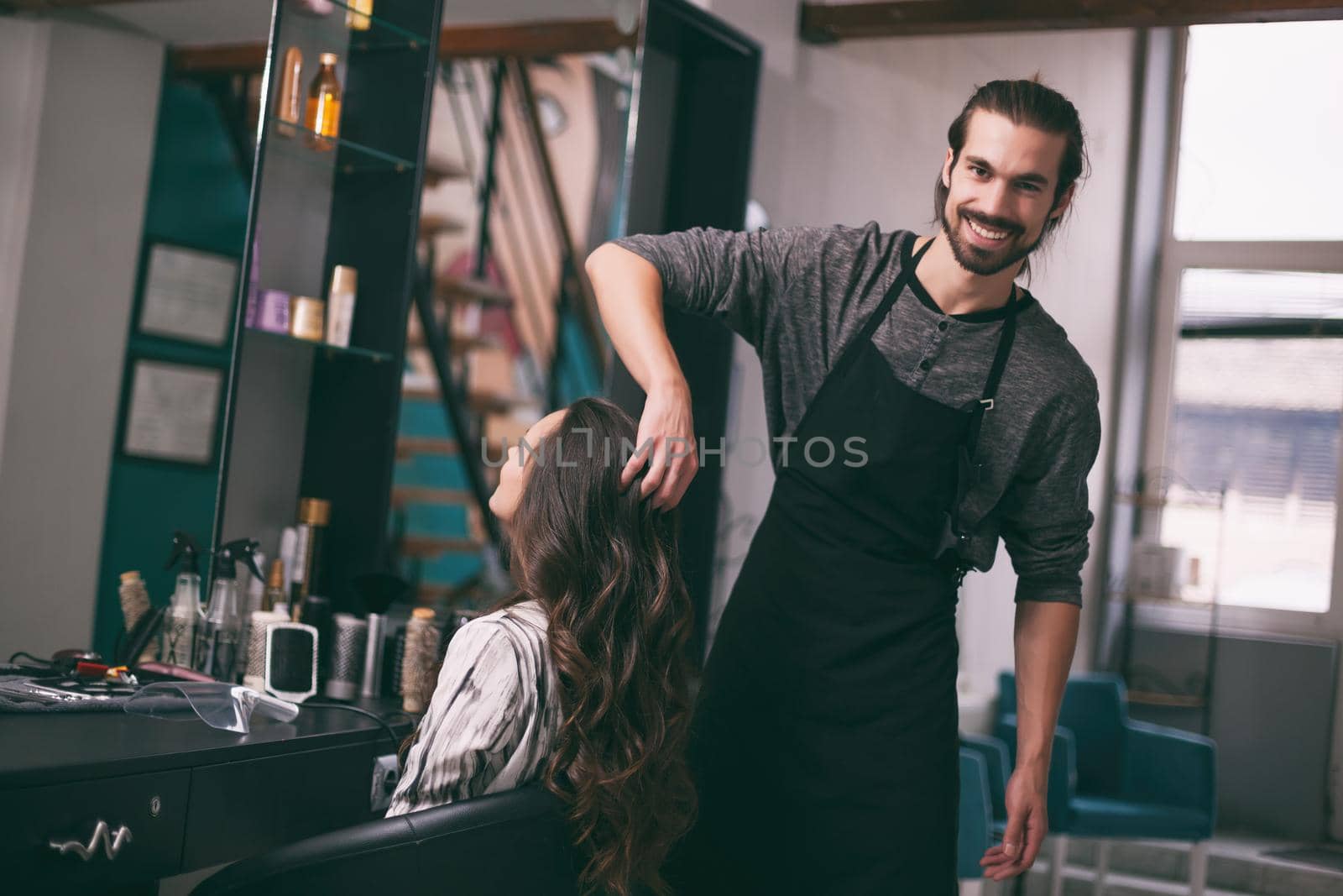 Young woman getting new hairstyle at professional hair styling saloon.