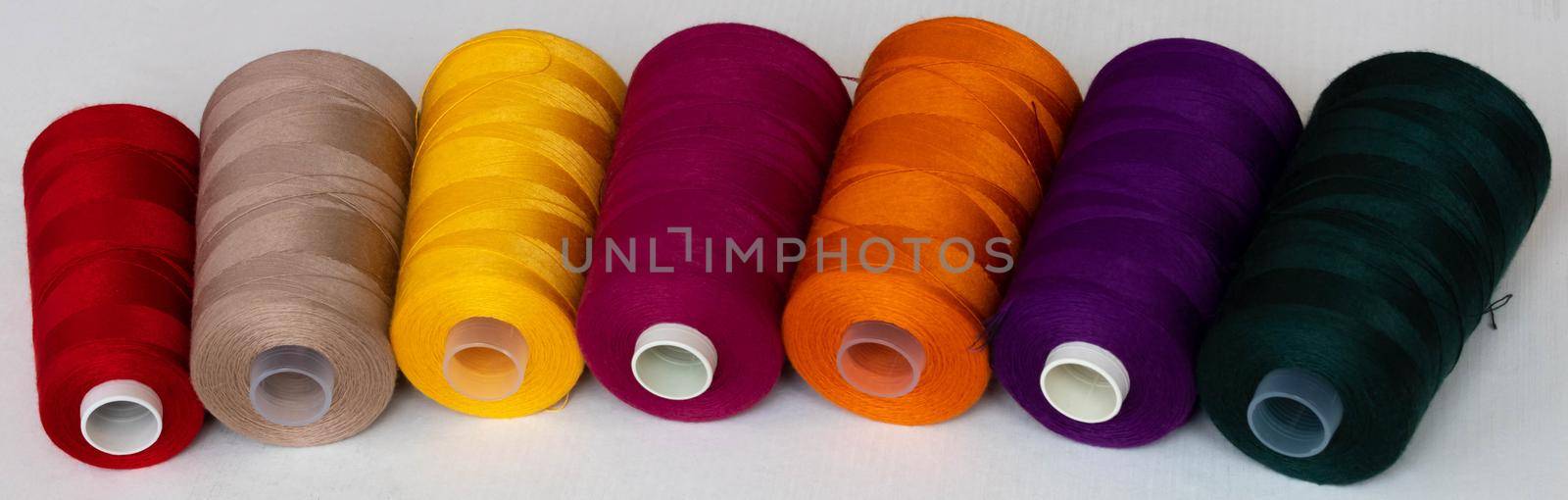 Panorama of colorful bobbins isolated on a white background.