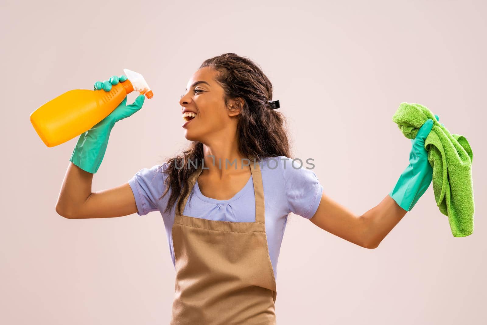 Portrait of african-american housewife who is ready for housework. She is happy and singing.