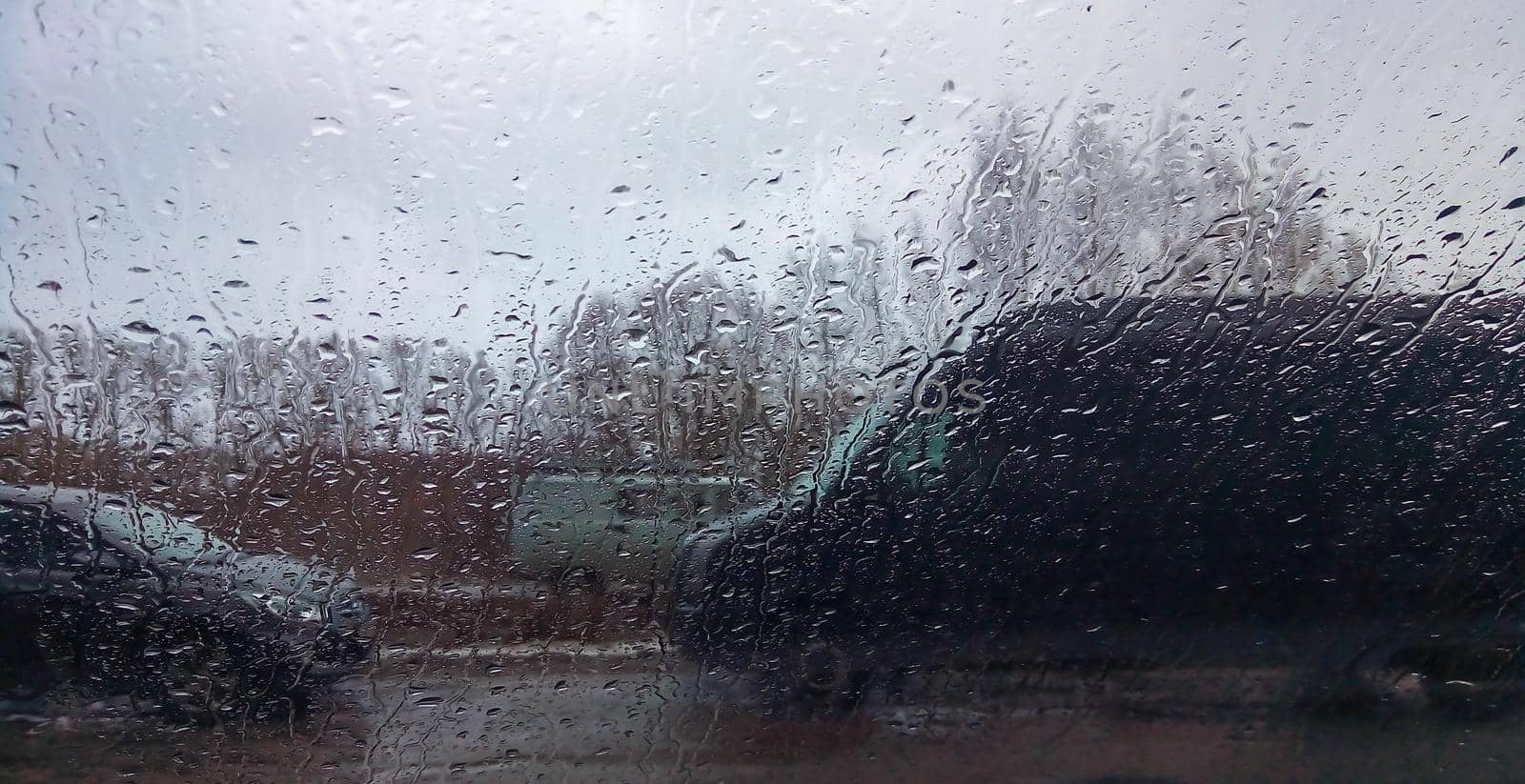 Raindrops on the window pane. Rainy city background.