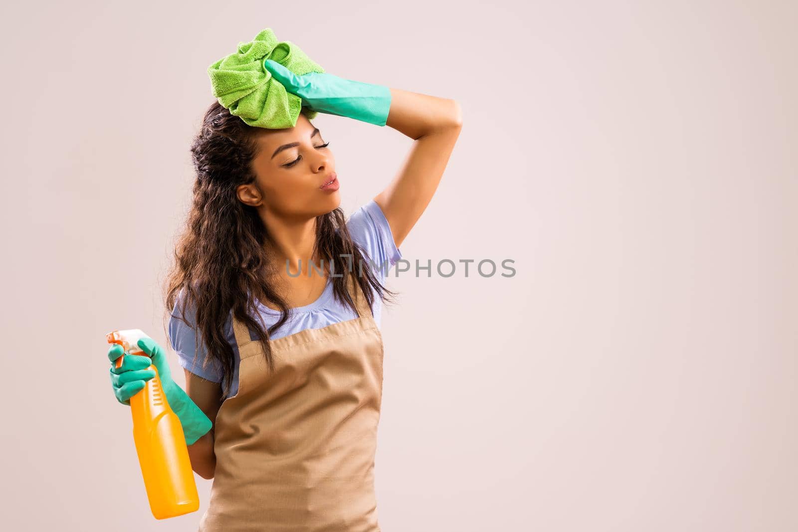 Portrait of african-american professional maid who is tired of cleaning.
