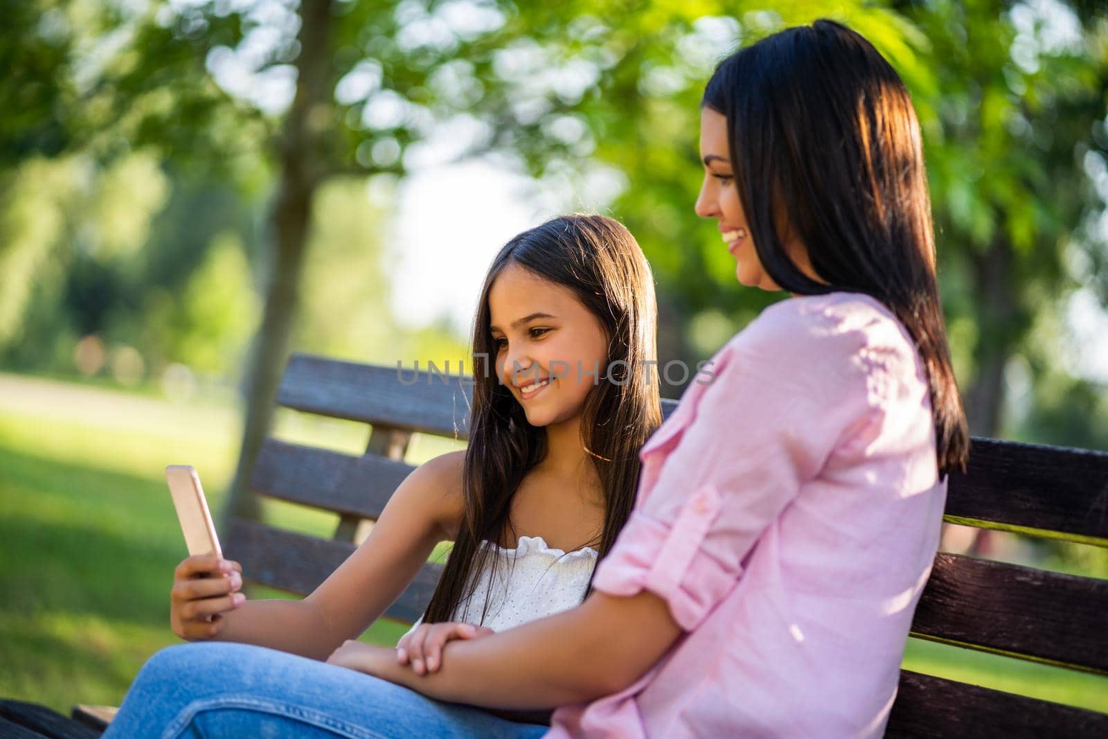 Happy family having nice time in park together. They are taking selfie.