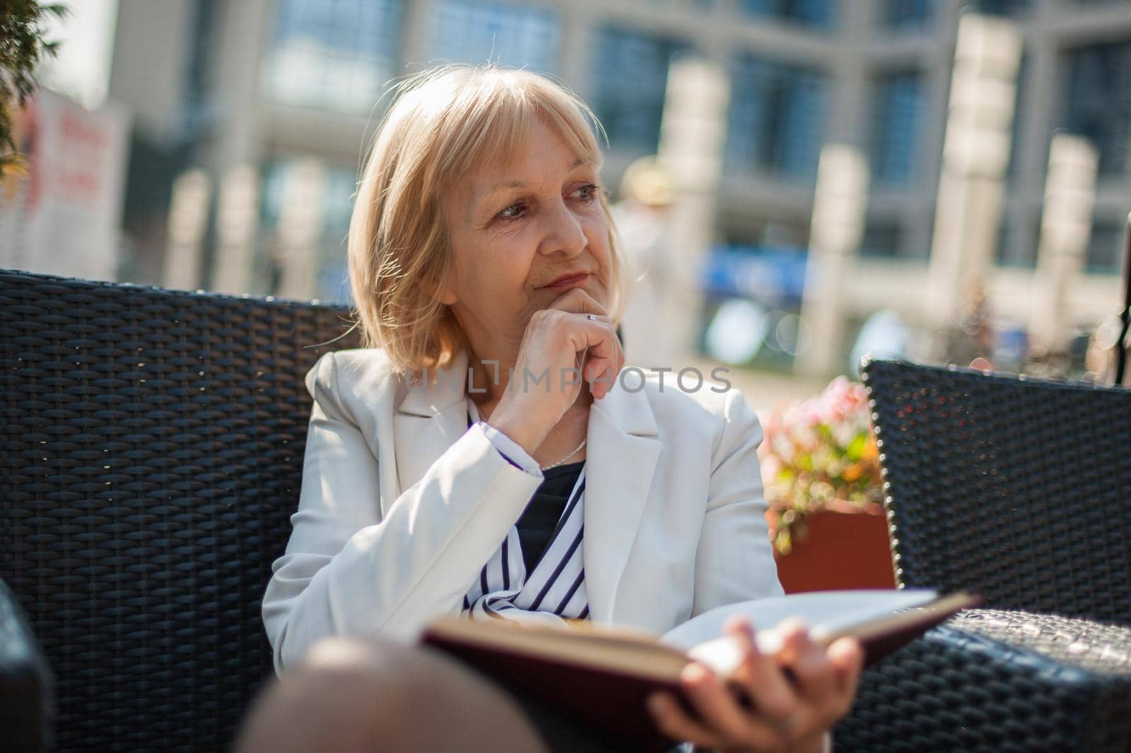 Senior businesswoman is sitting in cafe and making job plans.