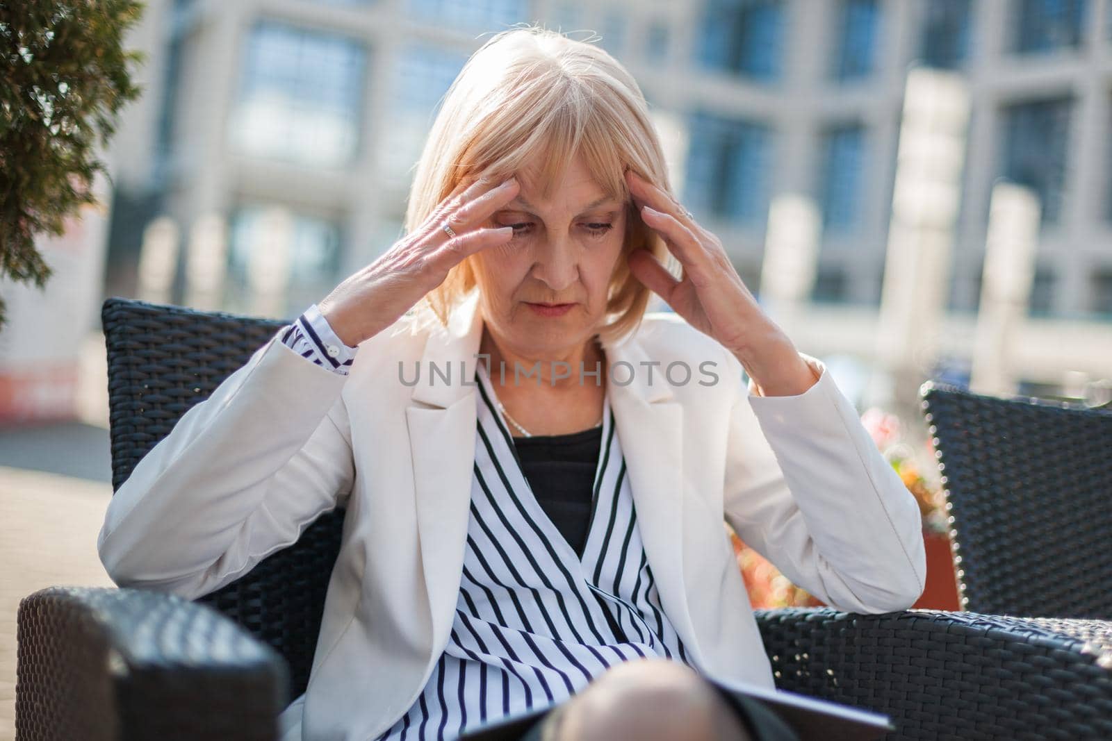 Senior businesswoman is sitting in cafe and making business plans.