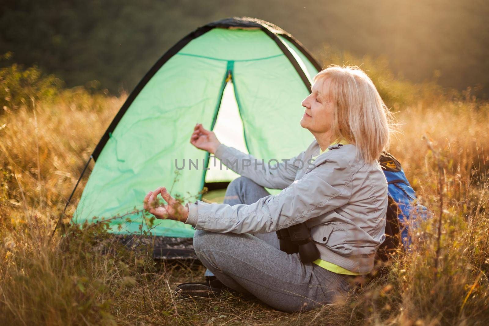 Senior woman is camping in mountain. Active retirement.