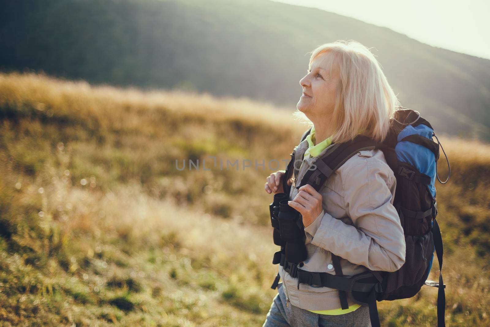 Senior woman is hiking in mountain. Active retirement.