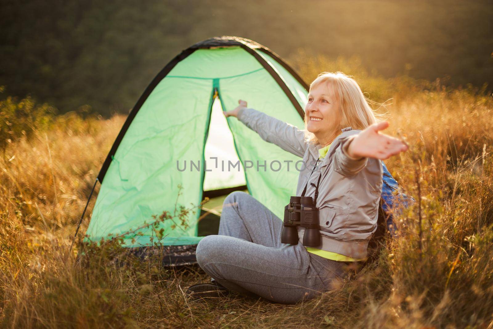 Senior woman is camping in mountain. Active retirement.