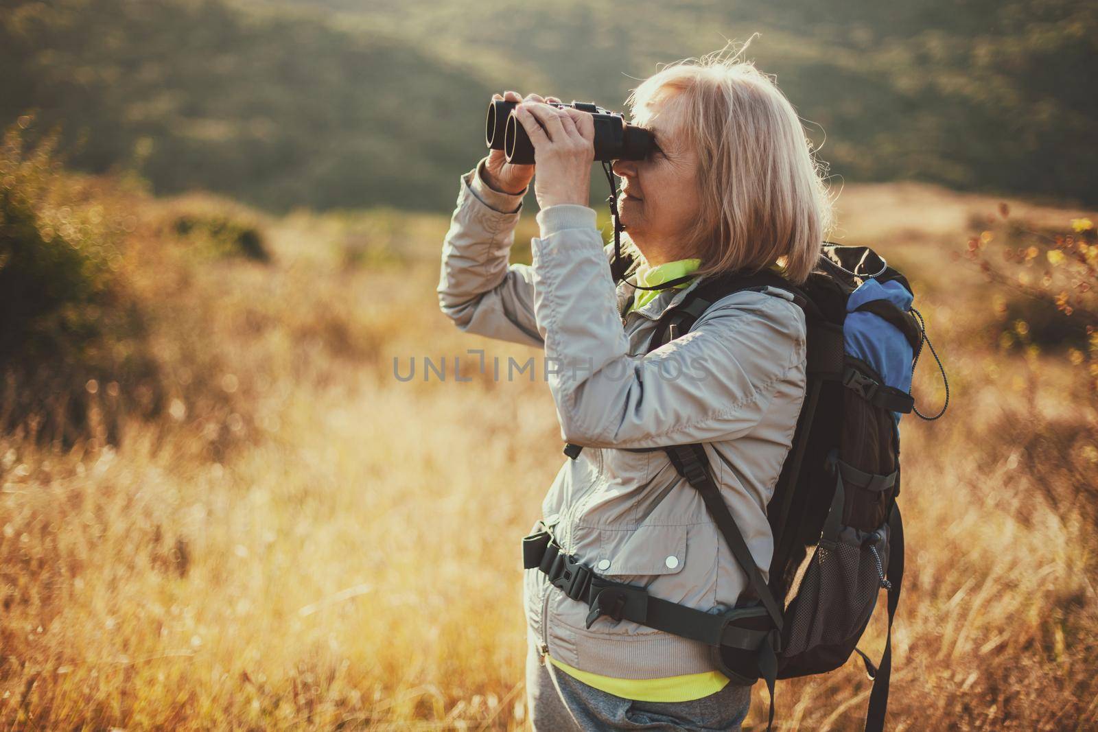 Senior woman is hiking in mountain. Active retirement.