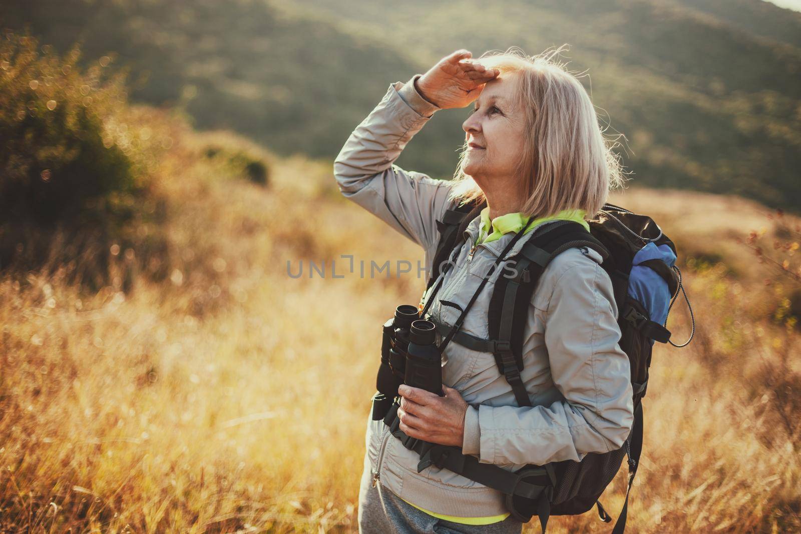 Senior woman is hiking in mountain. Active retirement.