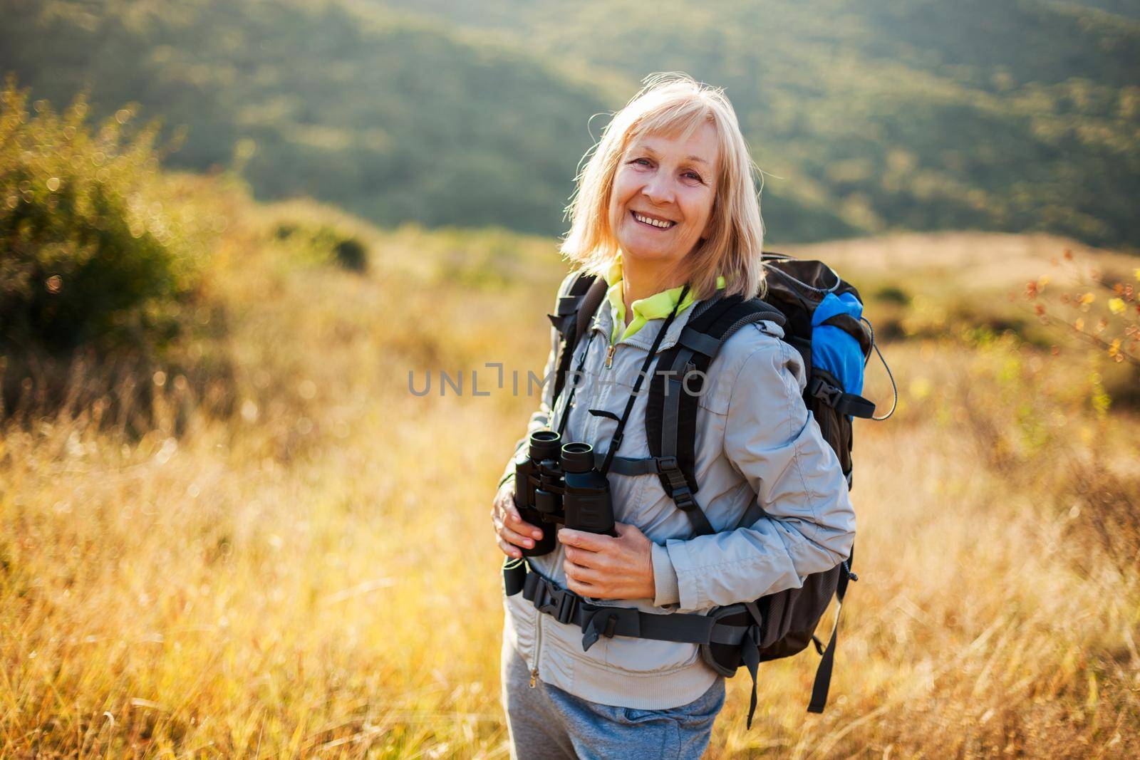 Senior woman is hiking in mountain. Active retirement.