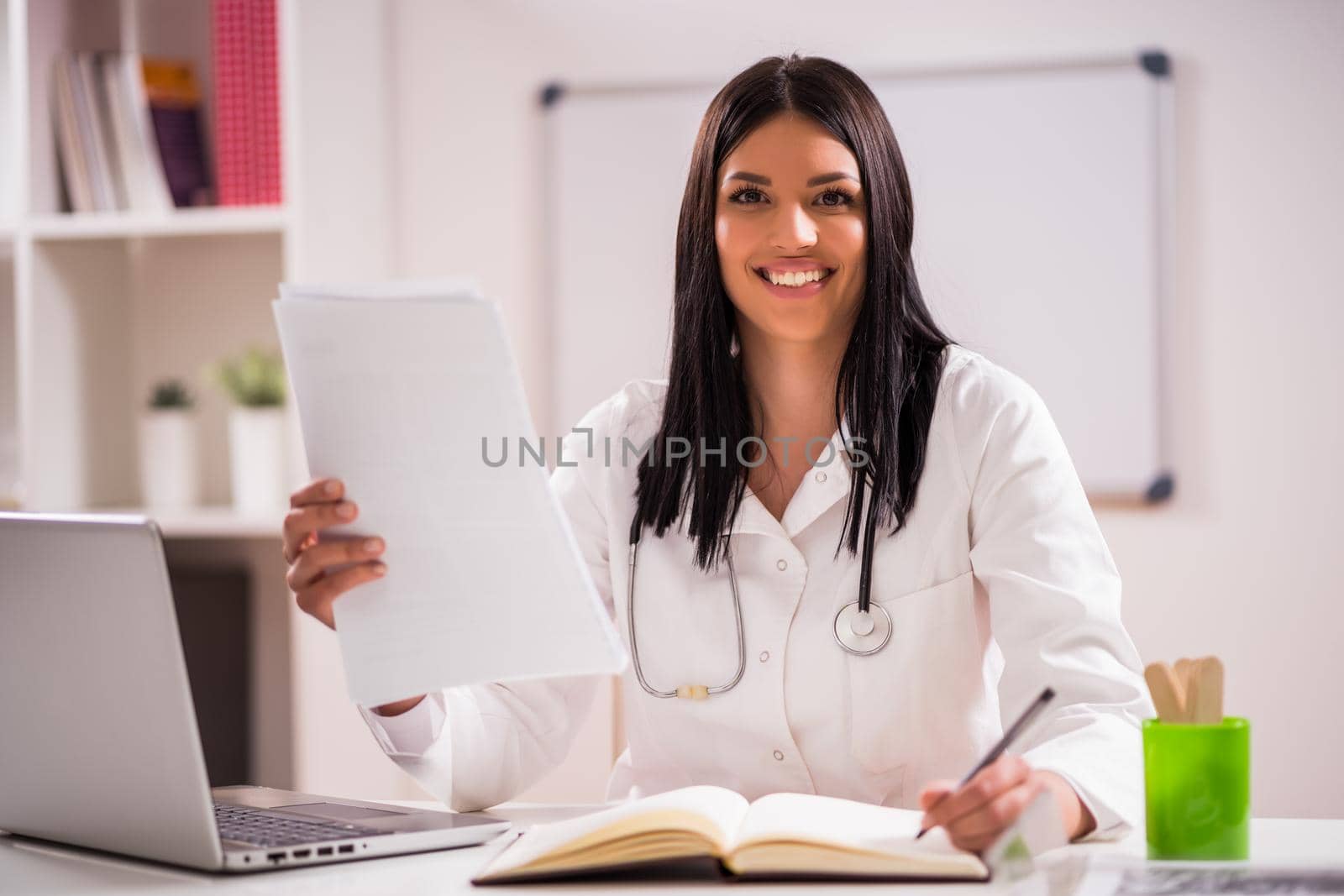 Portrait of young happy doctor in her office.
