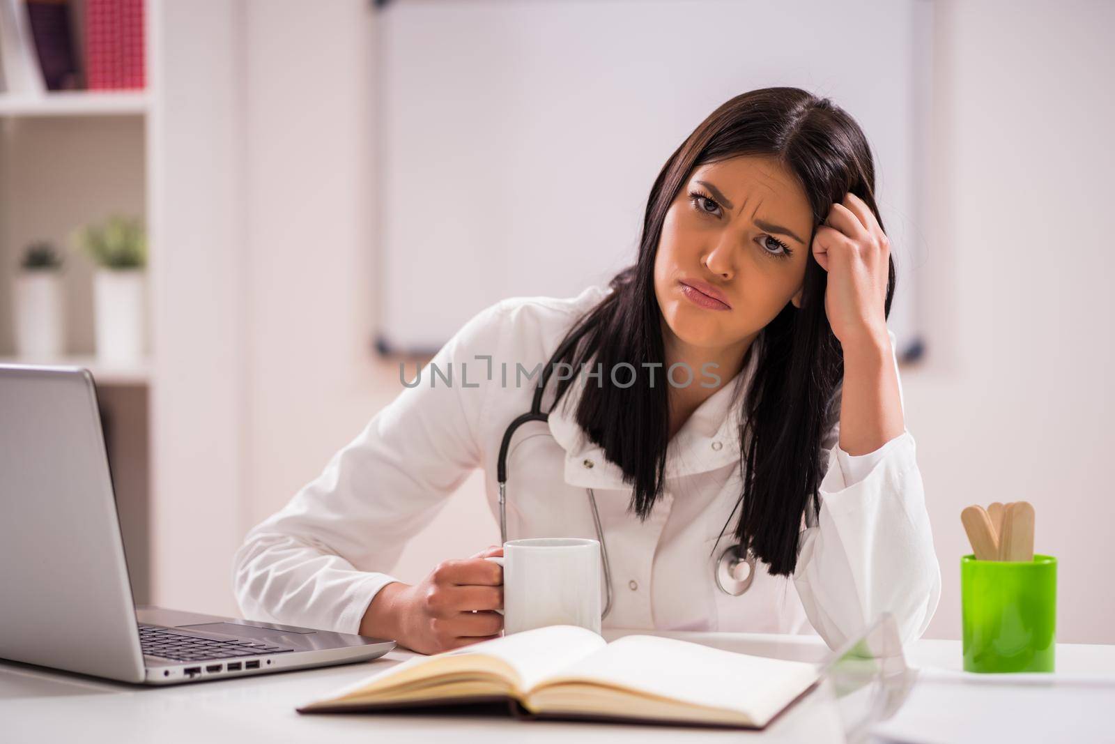 Portrait of tired doctor in her office.
