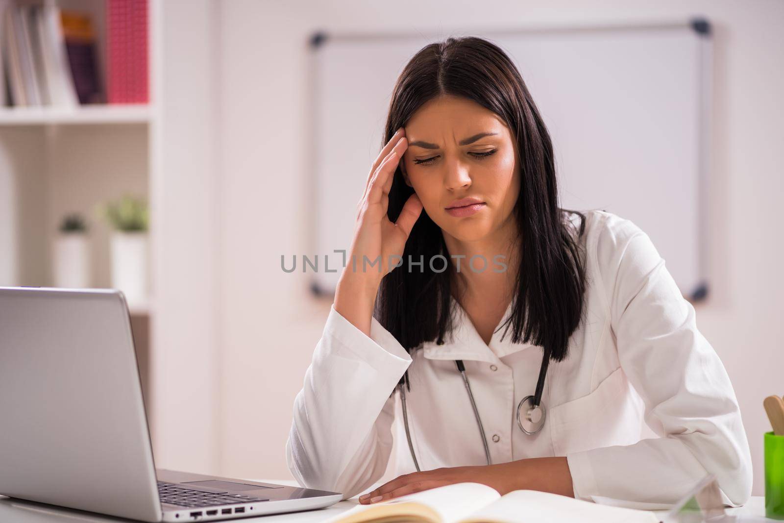 Portrait of tired doctor in her office.