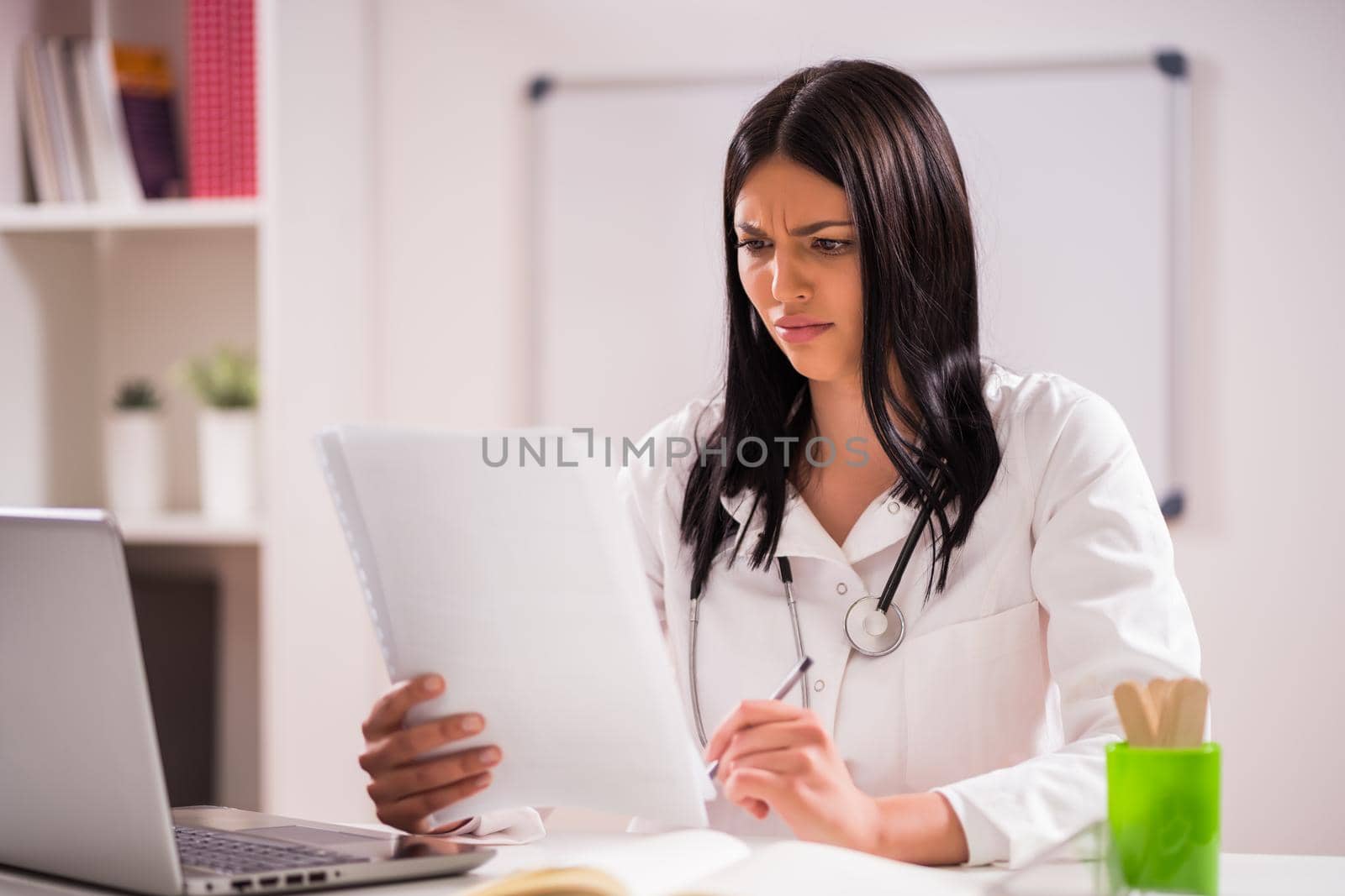 Portrait of worried doctor in her office.