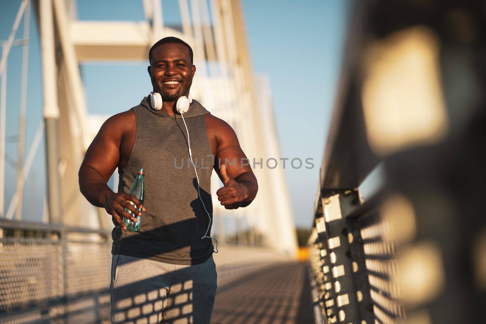 Portrait of young cheerful african-american man in sports clothing who is looking at camera and smiling.