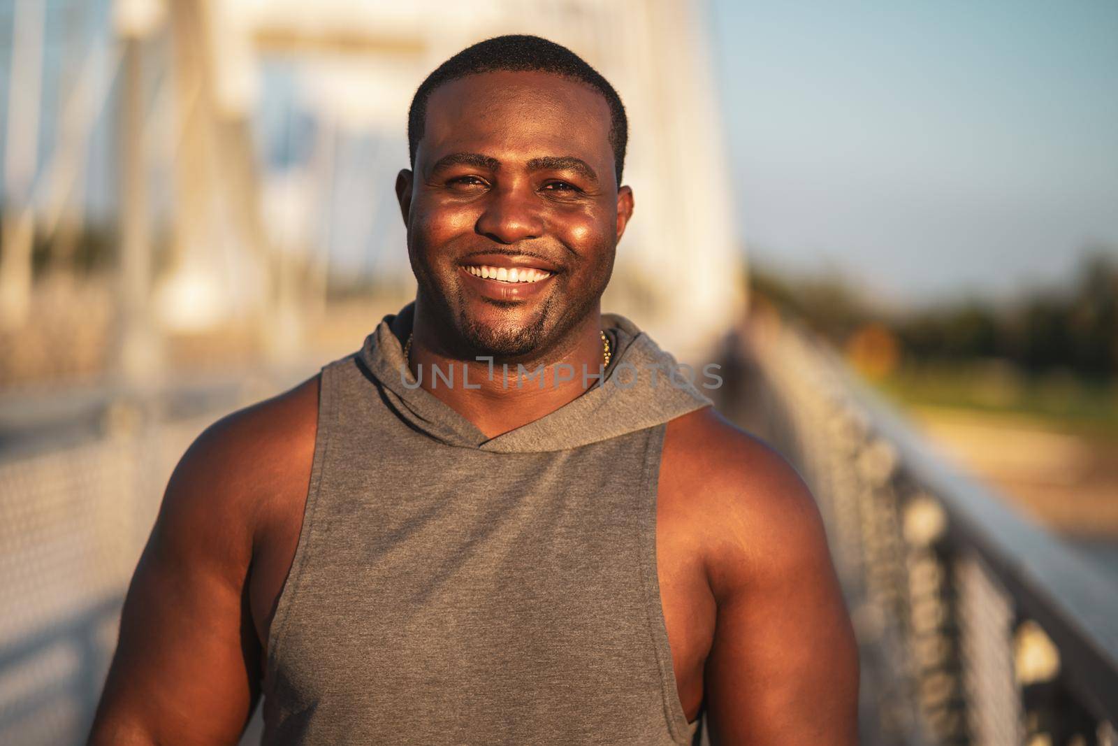 Portrait of young cheerful african-american man in sports clothing who is looking at camera and smiling.