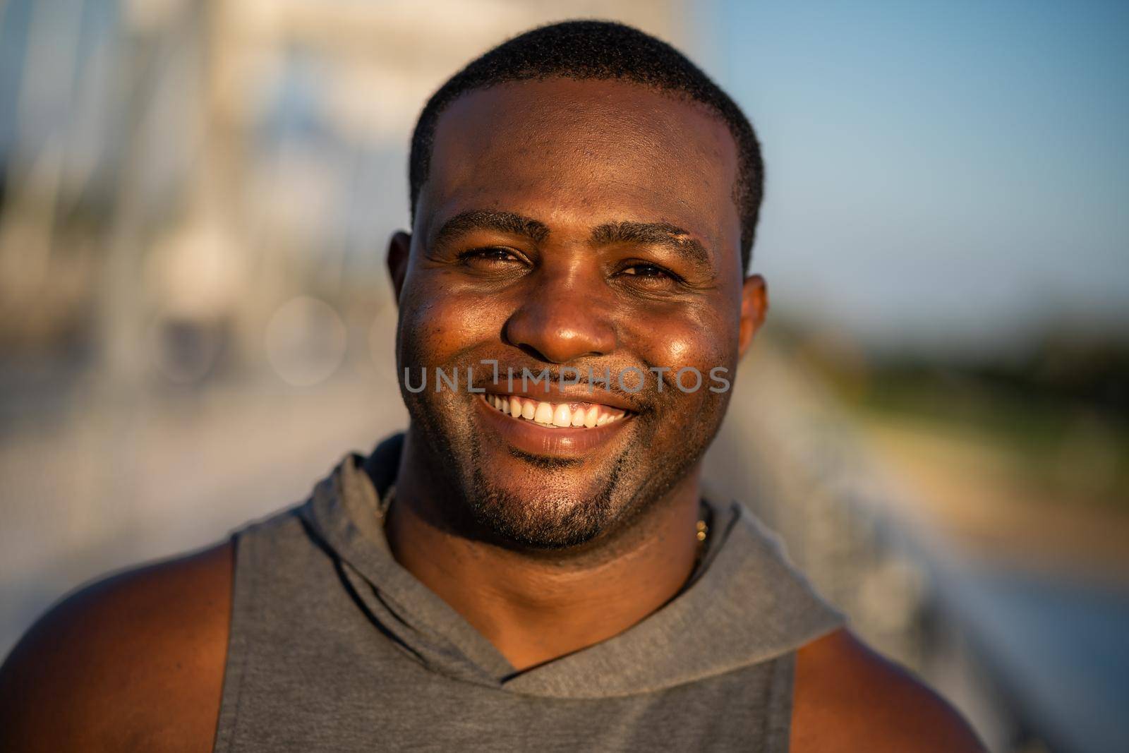 Portrait of young cheerful african-american man in sports clothing who is looking at camera and smiling.