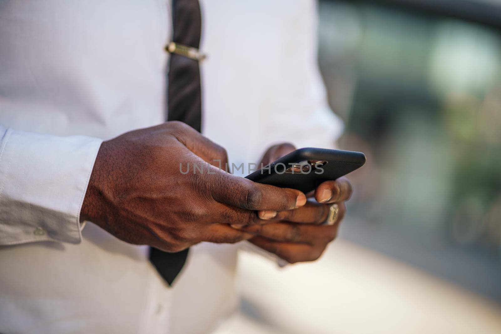 Close up of african-american businessman who is using smartphone.