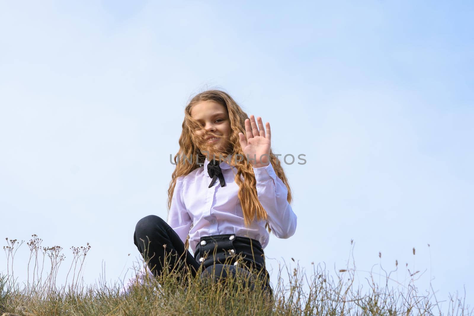 A girl in a white shirt with a bow tie sits on the ground in a field against the background of the sky and waves a pen to the frame by Madhourse