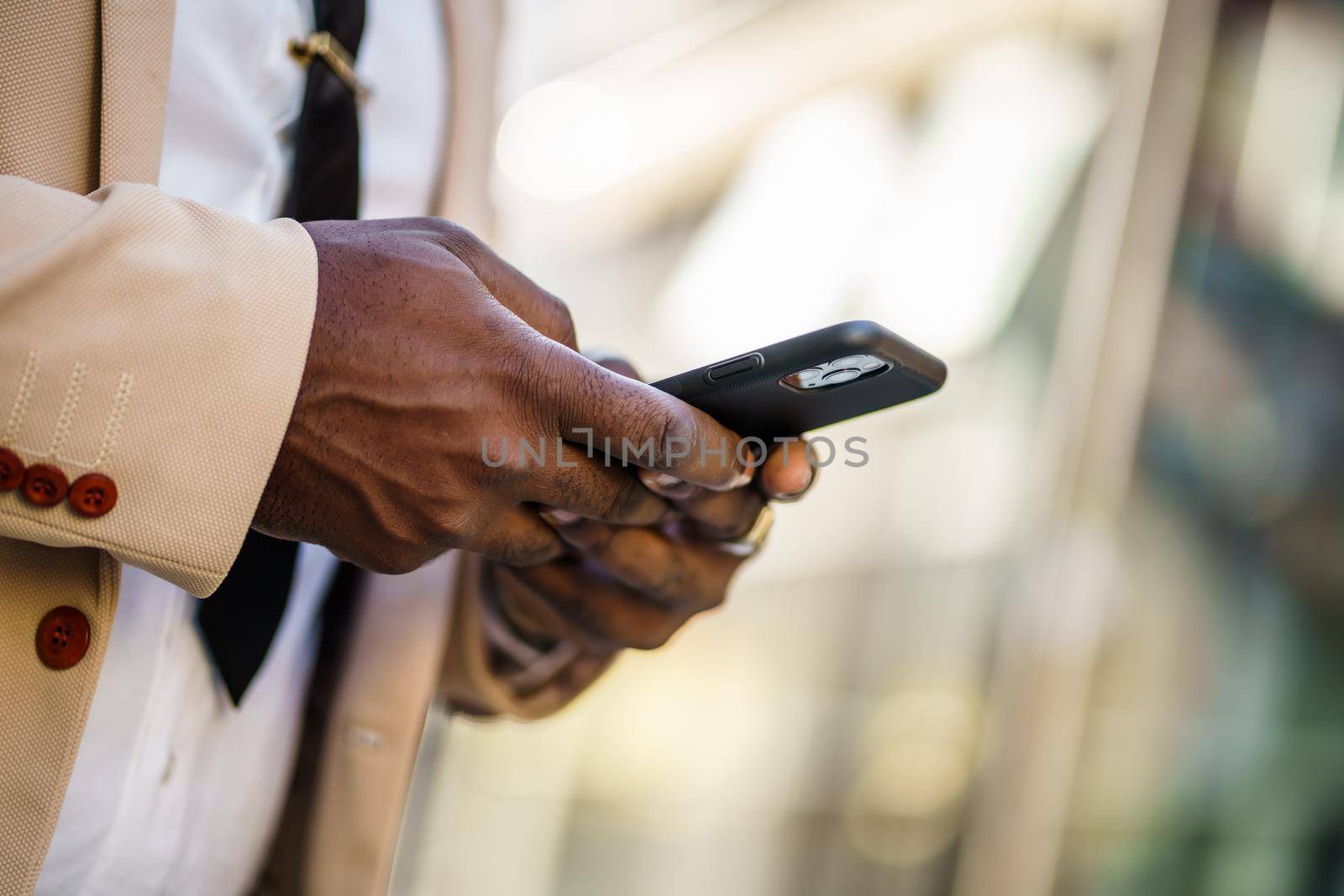 Close up of african-american businessman who is using smartphone.