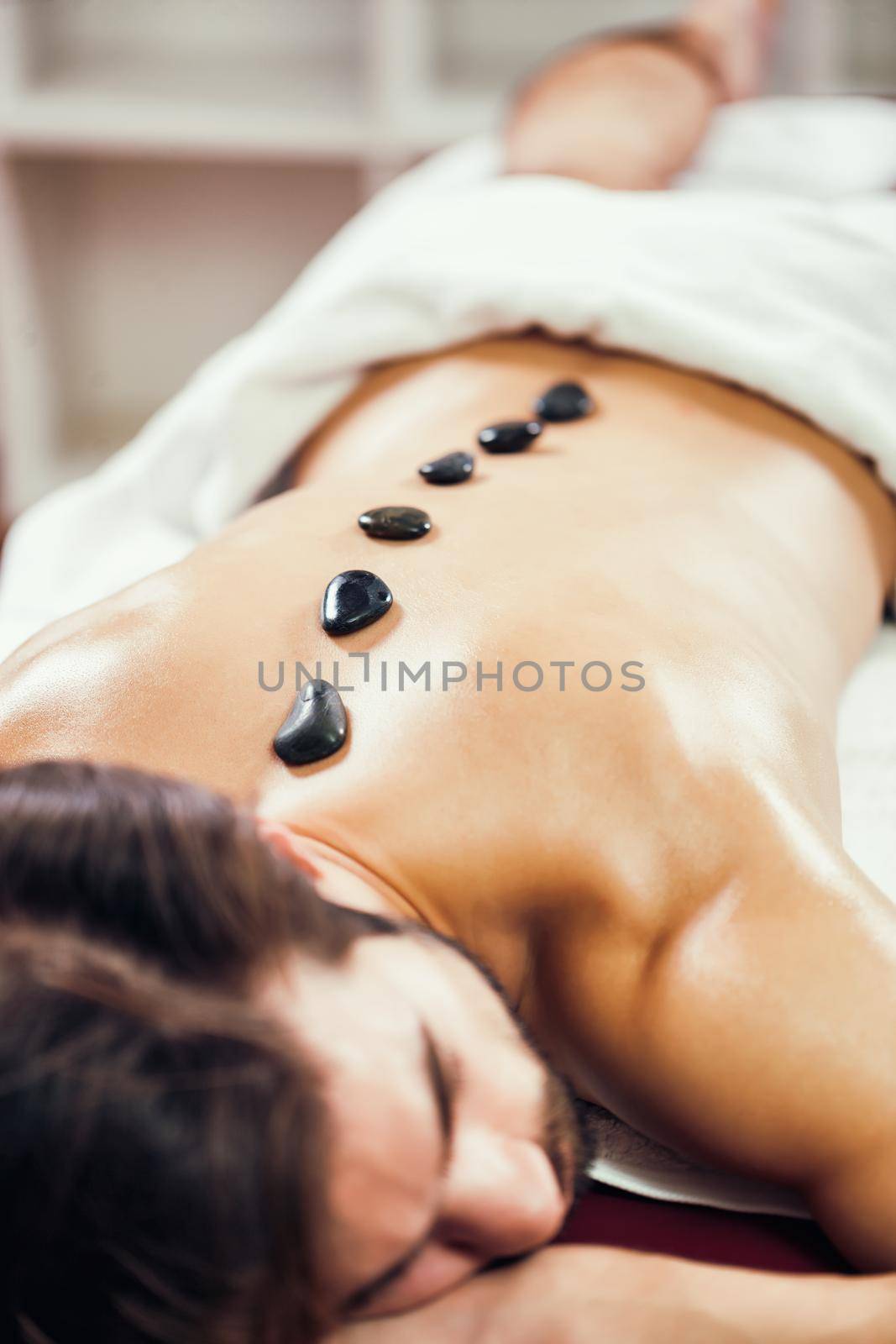 Young man is having massage on spa treatment.