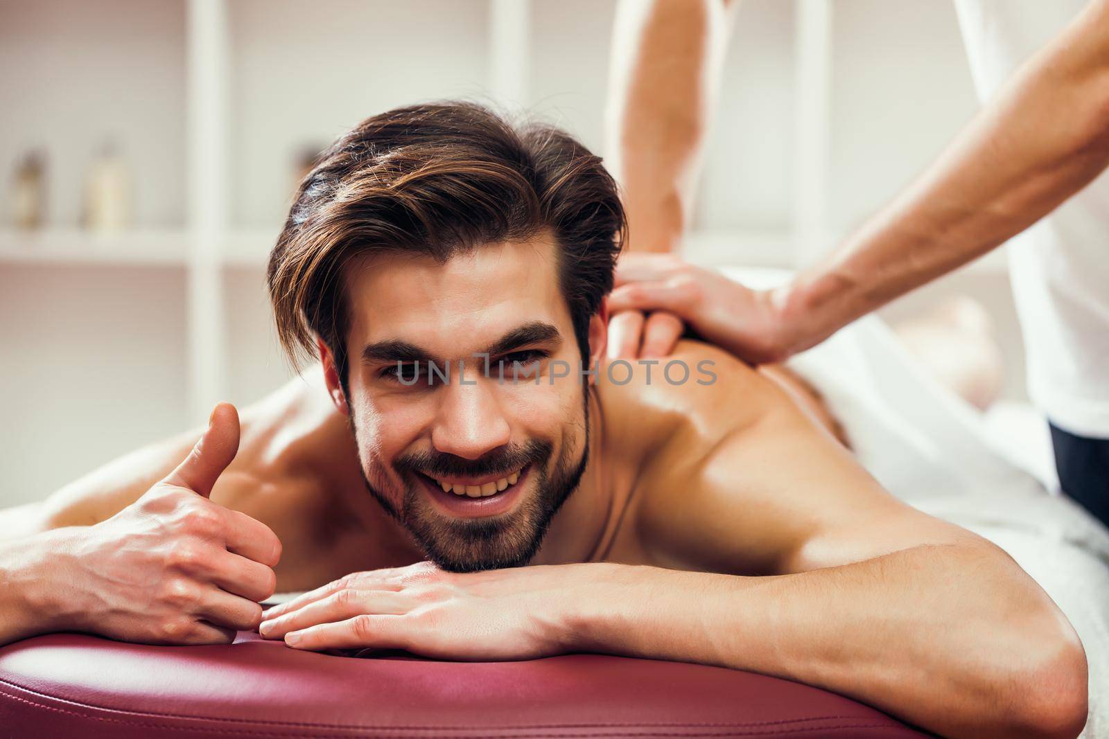 Young man is enjoying massage on spa treatment.