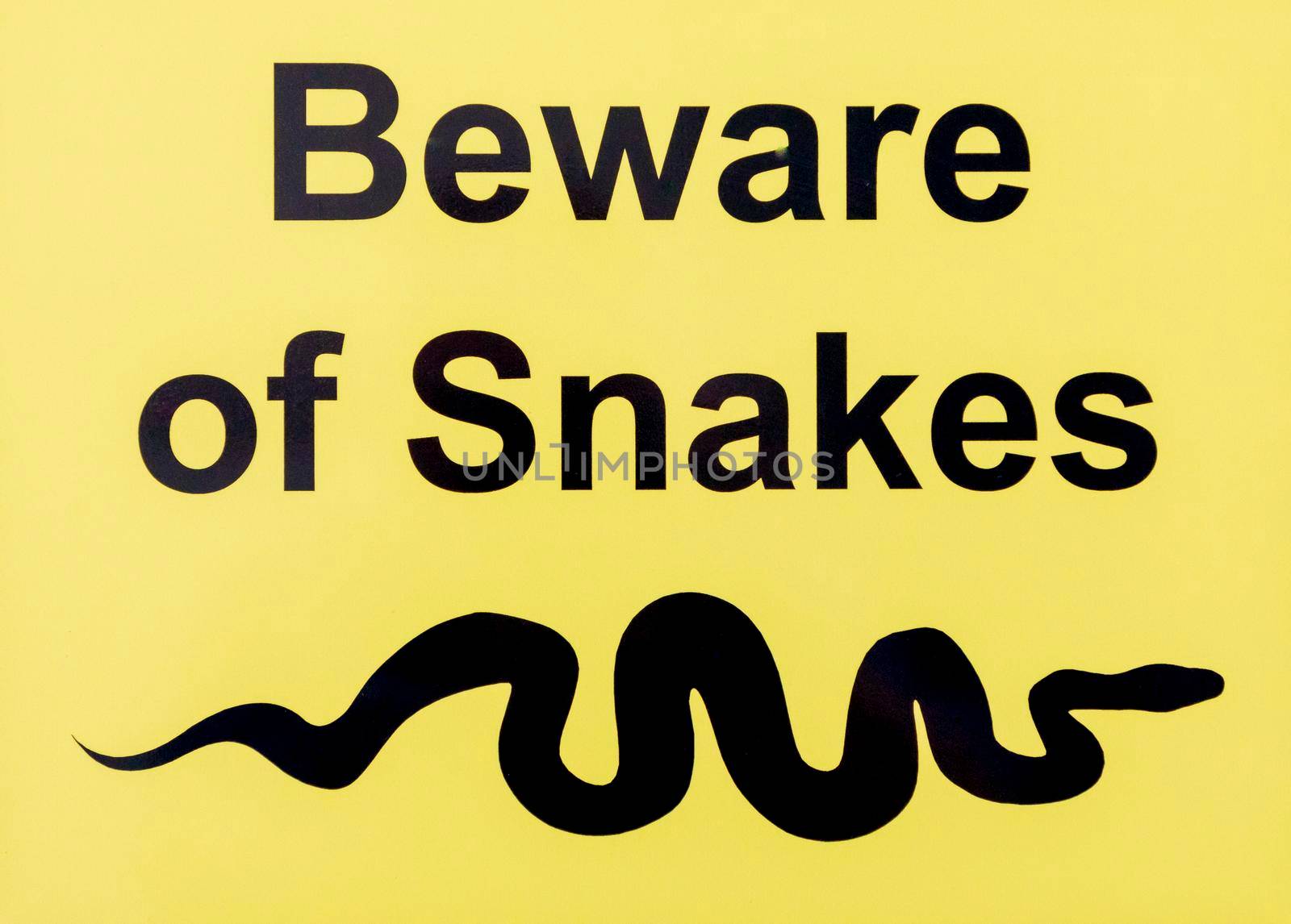 A yellow and black beware of snakes sign