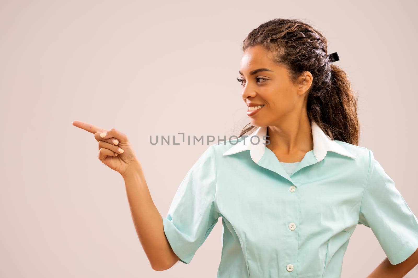 Portrait of young nurse who is pointing at your text or product.