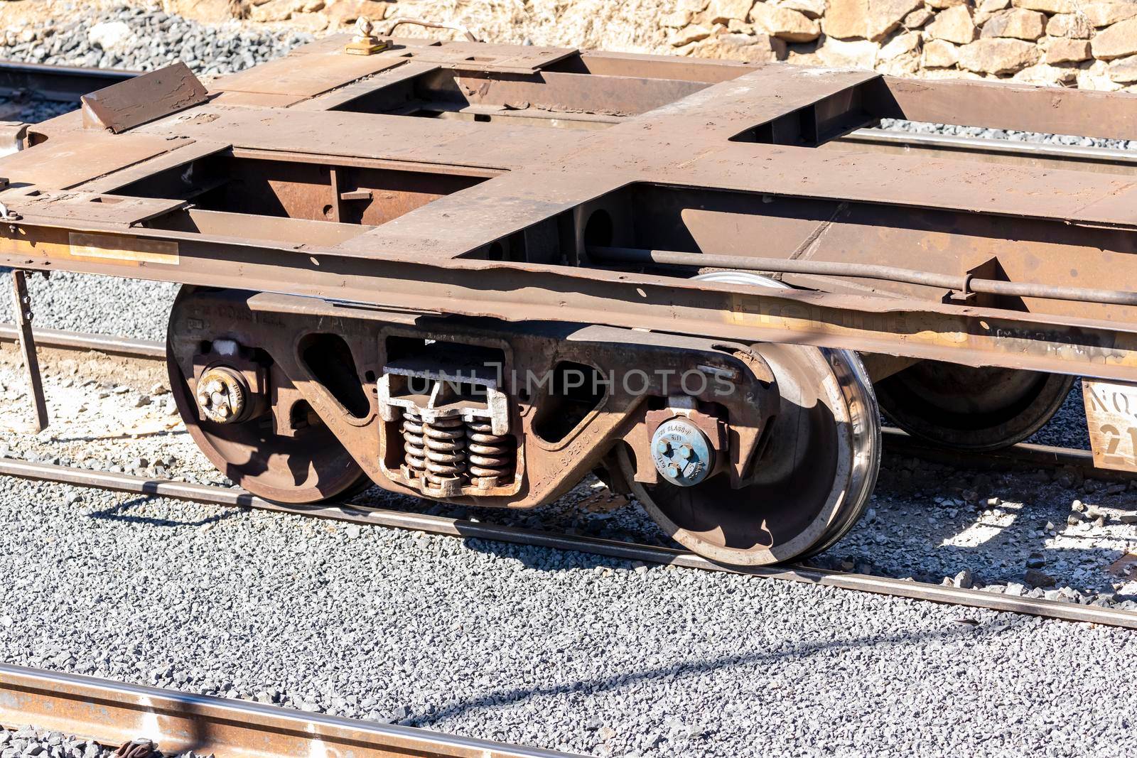 Old and rusty train wheels on a flat bed carriage by WittkePhotos