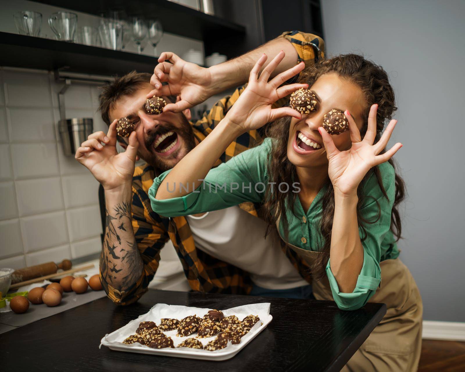 Happy multiracial couple have made cookies in their kitchen.