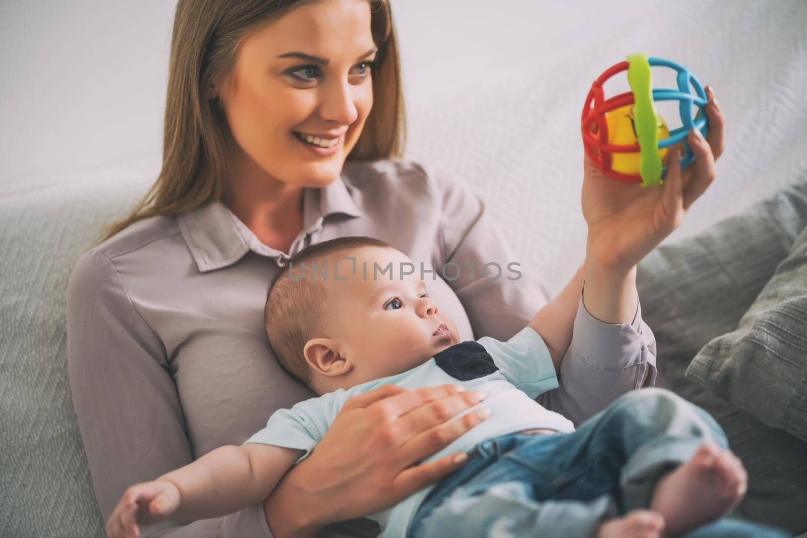 Happy mother and her baby boy playing at home.