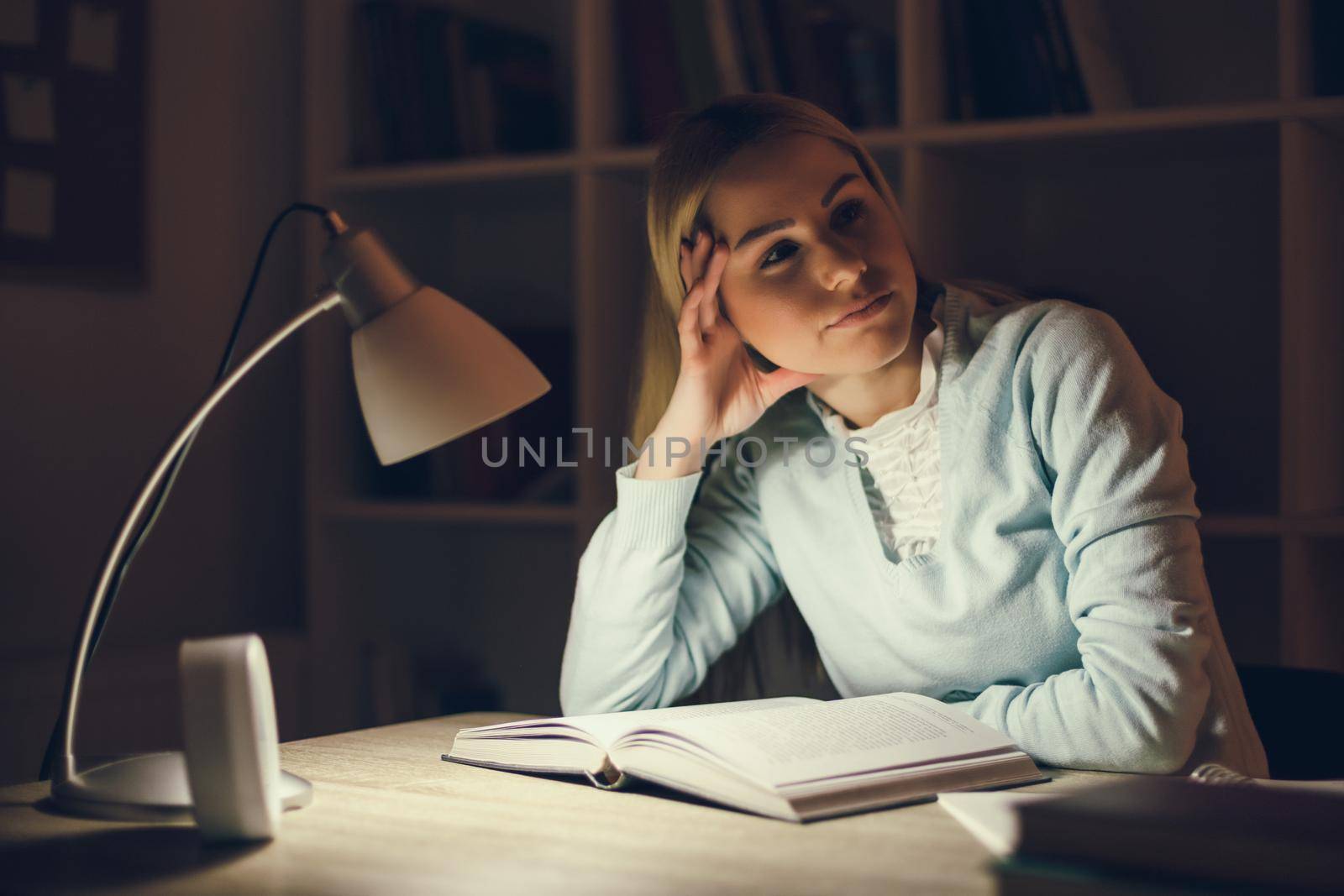 Tired student learning at home at night.