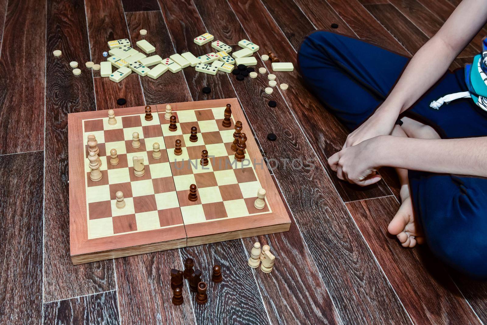 boy plays checkers, chess, dominoes and backgammon. set of board games