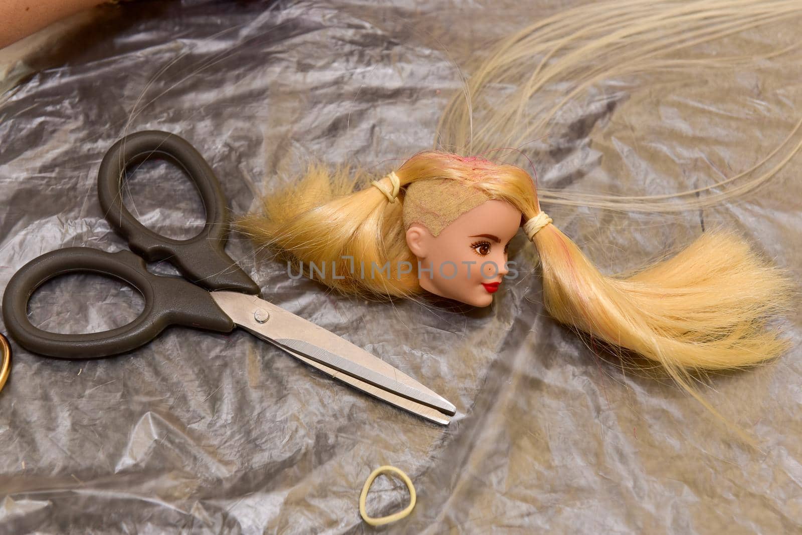 scissors and doll head on the table, how to make a doll hairstyle, hobby concept.