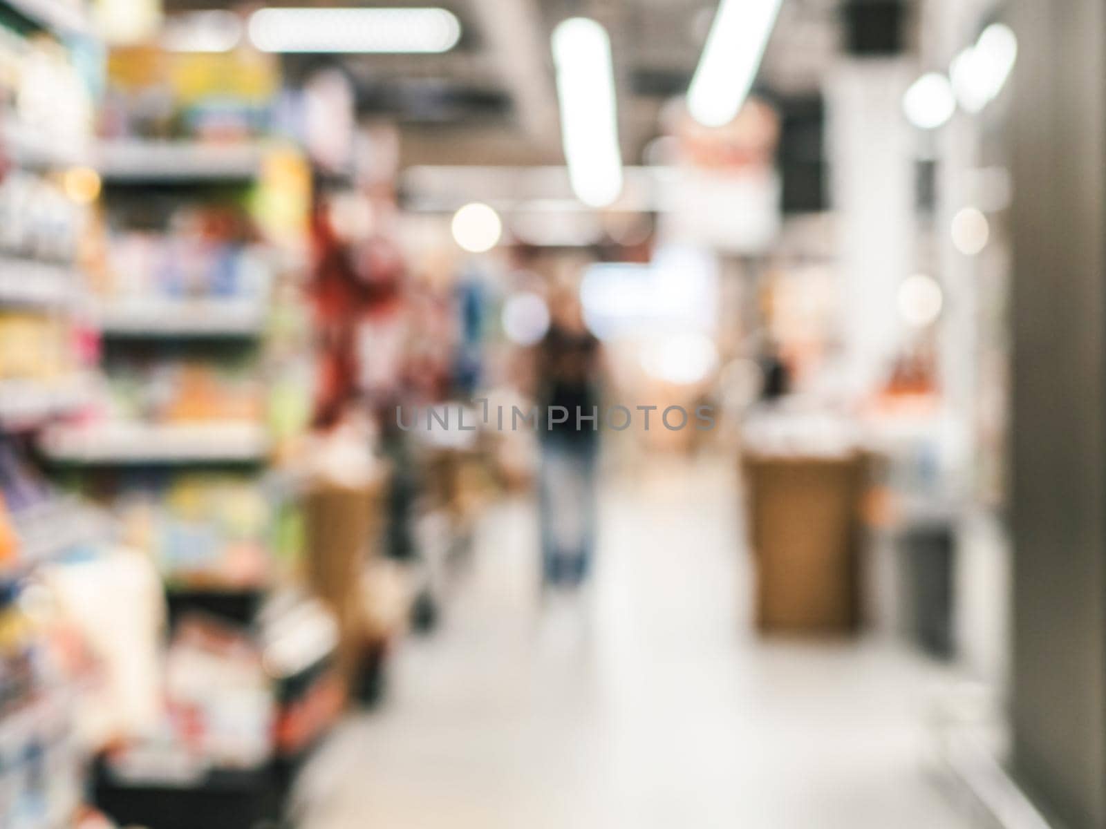 Abstract blurred supermarket aisle with colorful shelves and unrecognizable customers as background