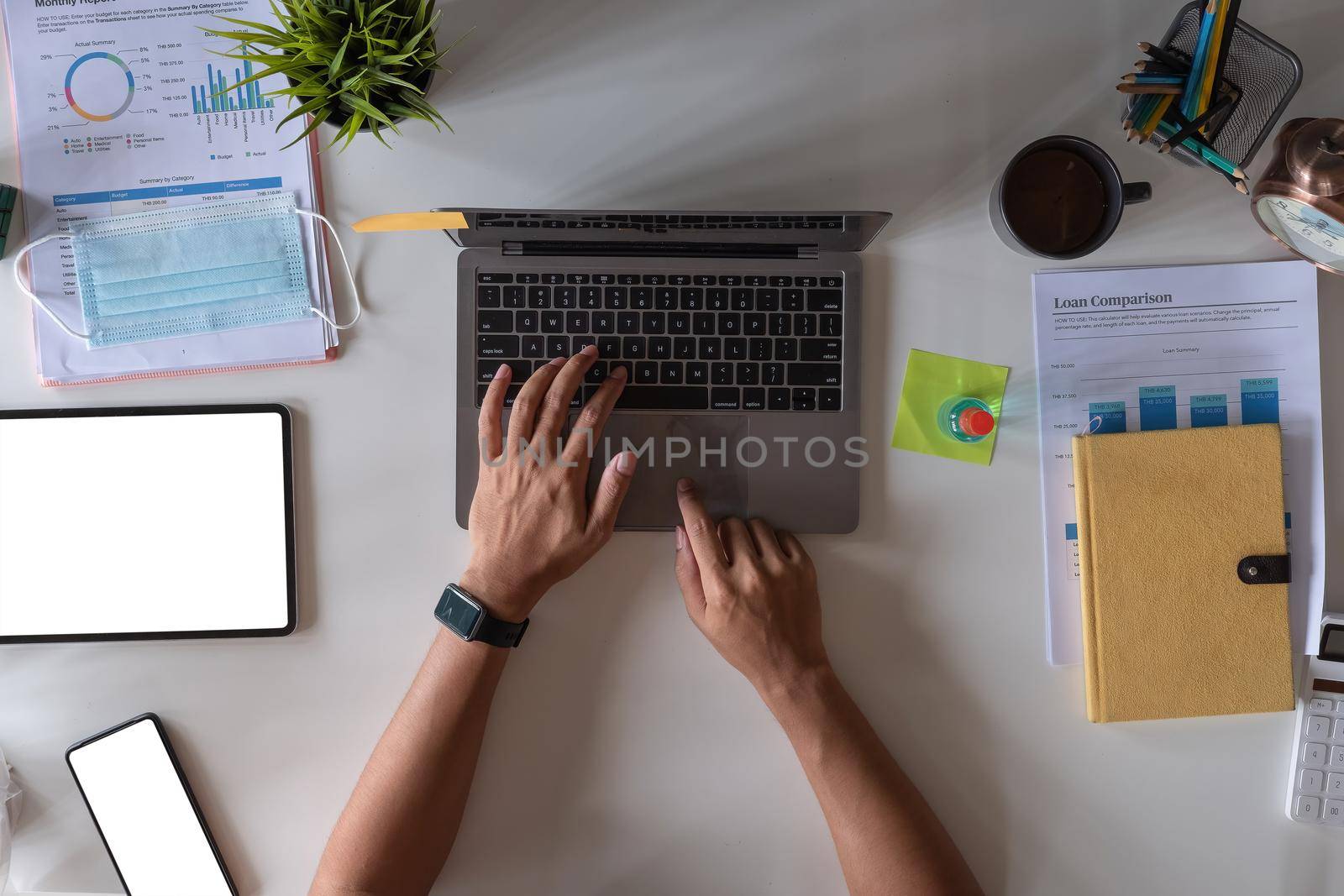 Top view of male hands working on modern laptop. Office desktop on white background, business accounting concept
