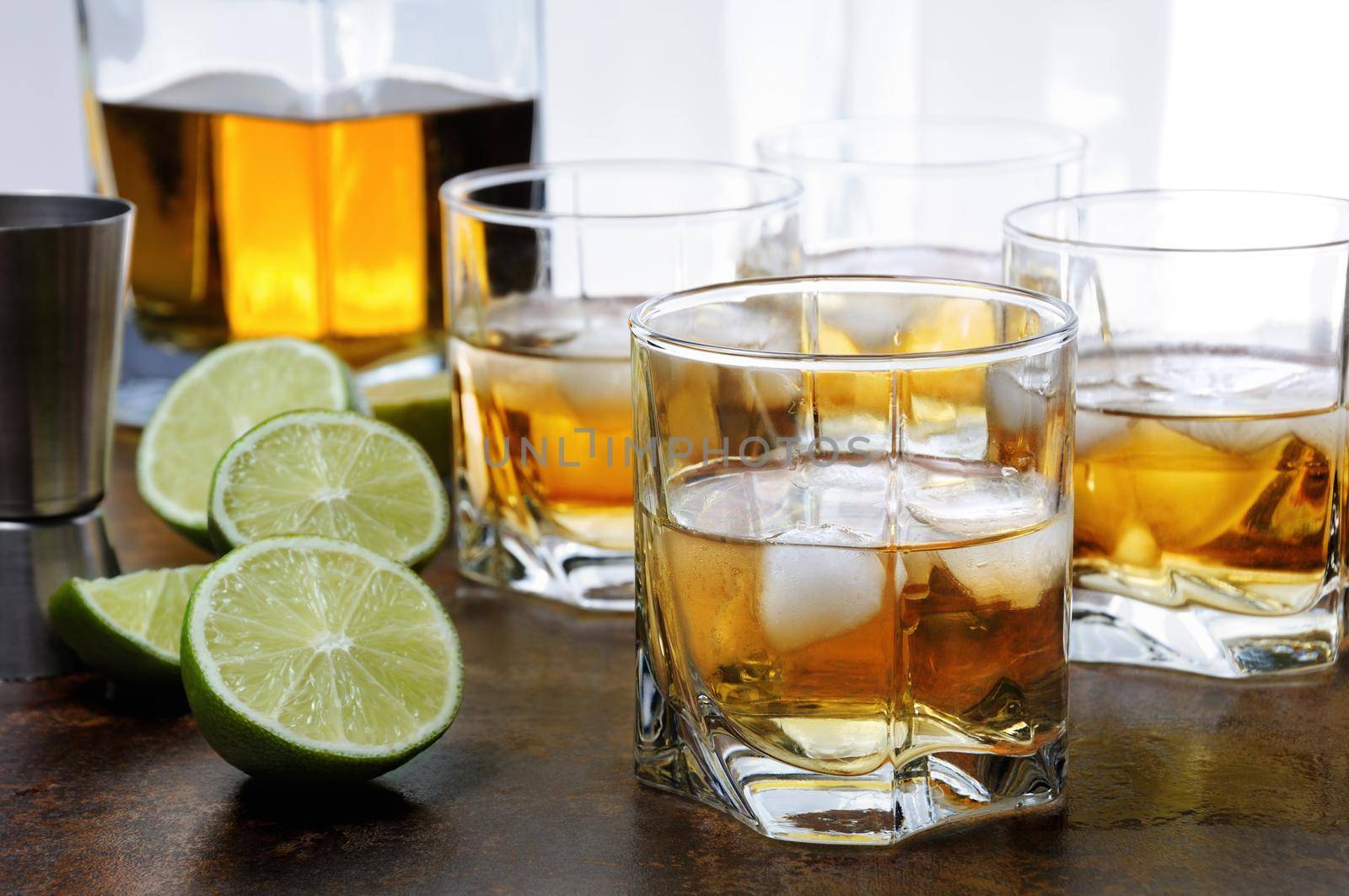Alcohol cocktail with brandy, whiskey or rum with Ginger Ale, lime and ice in glasses  